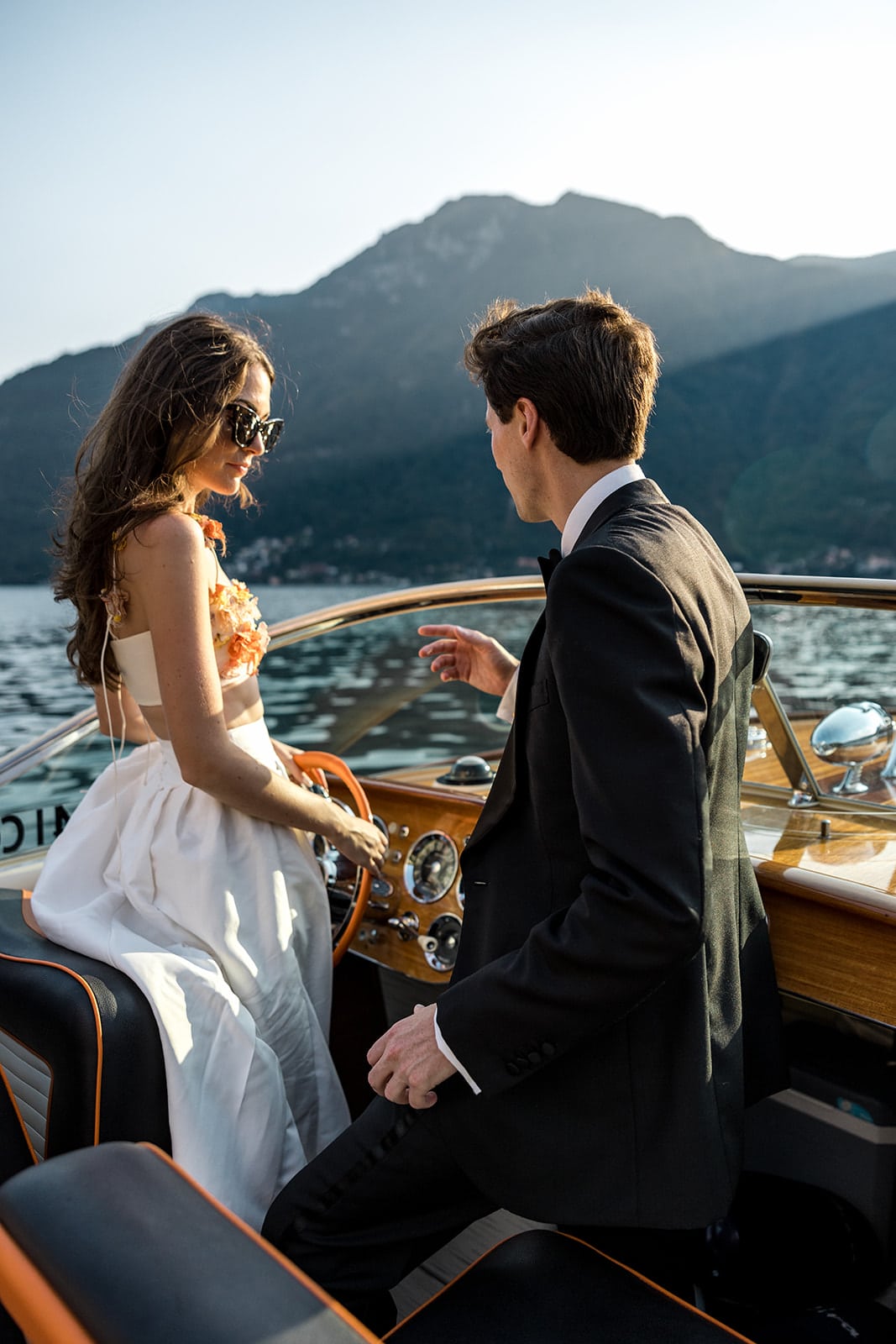 Couple stand together on a boat on Lake Como