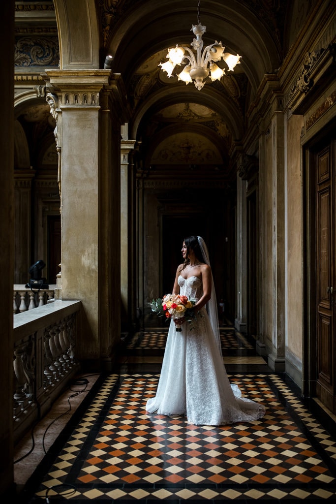 Bride stands in halls of Villa Erba wedding venue before Lake Como destination wedding