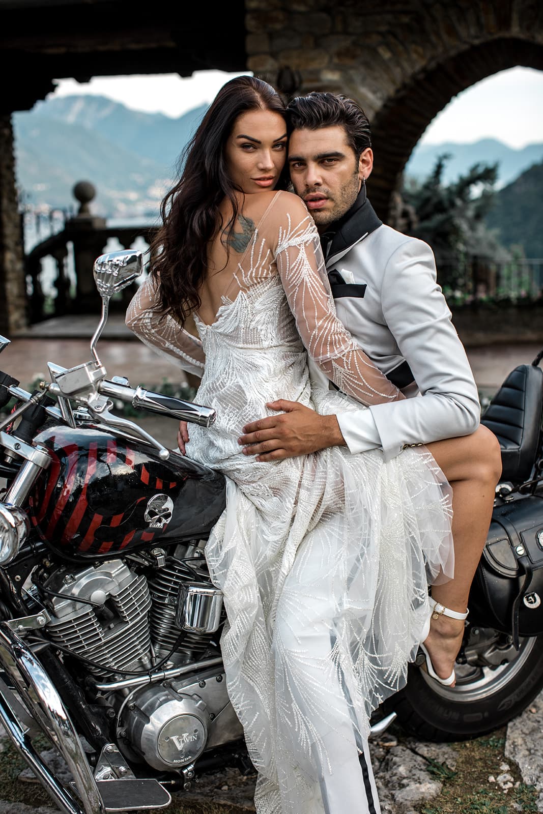Groom embraces bride on motorcycle