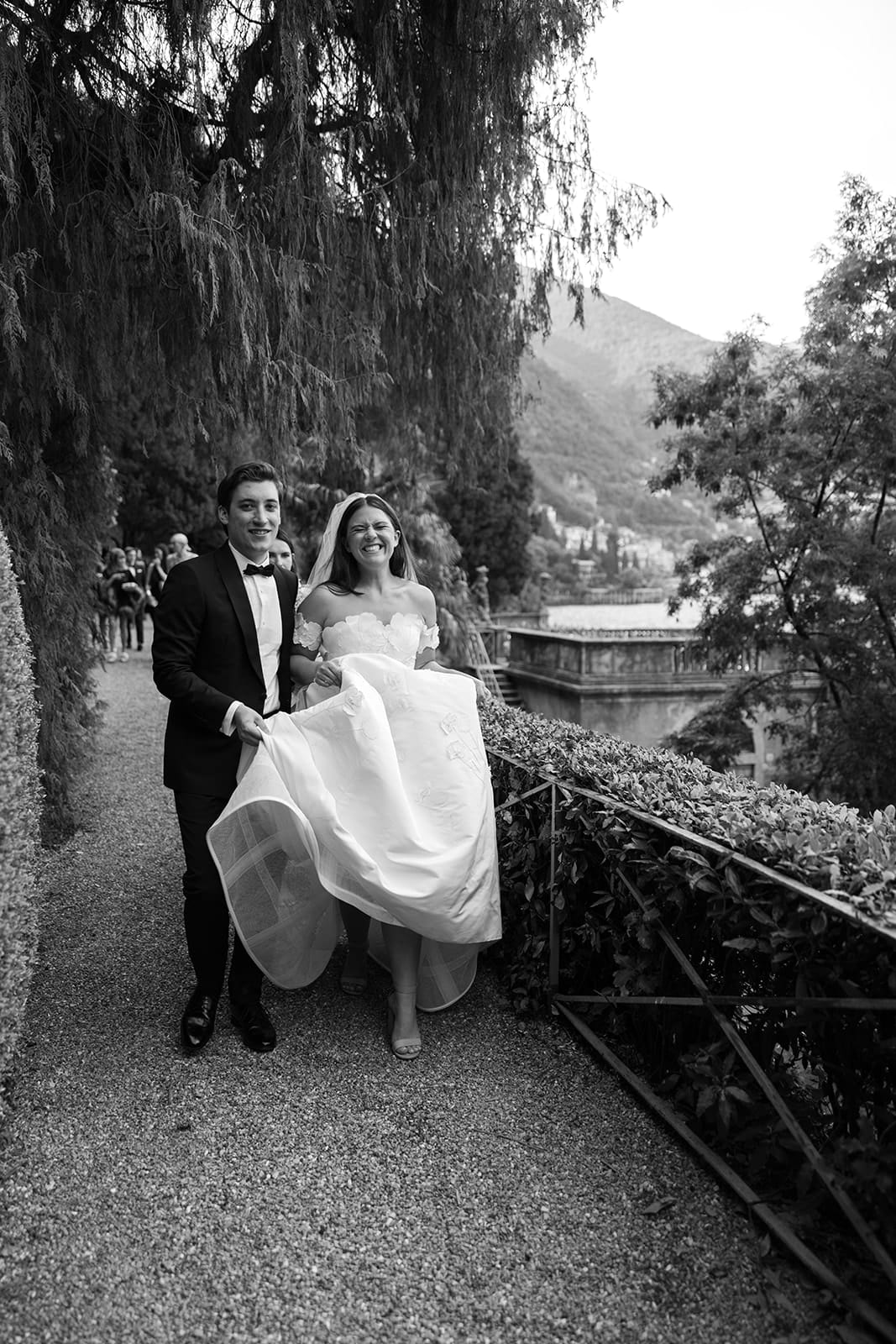 Bride and groom walk in garden at Villa Pizzo, Lake Como