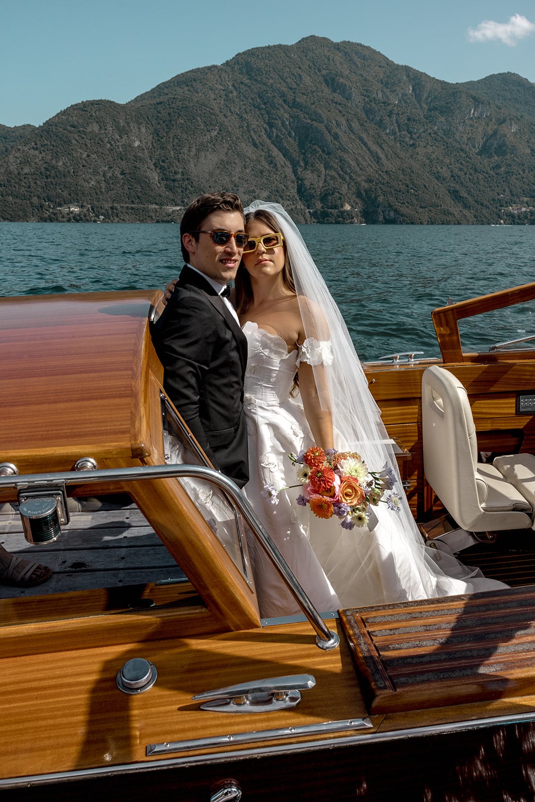 Bride and groom stand in Riva on Lake Como