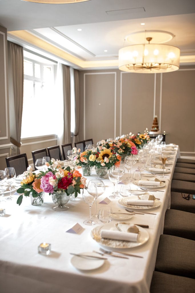Banquet-style table is set with floral centerpieces at The Cadogan for wedding luncheon