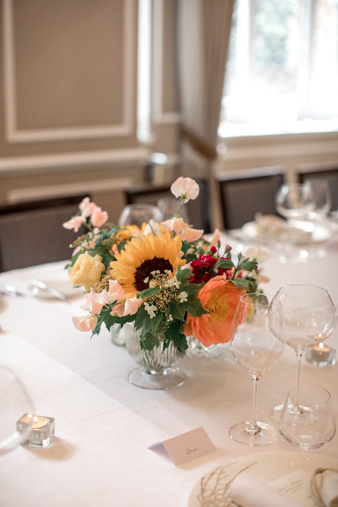 A bright floral centerpiece of sunflowers and roses at The Cadogan