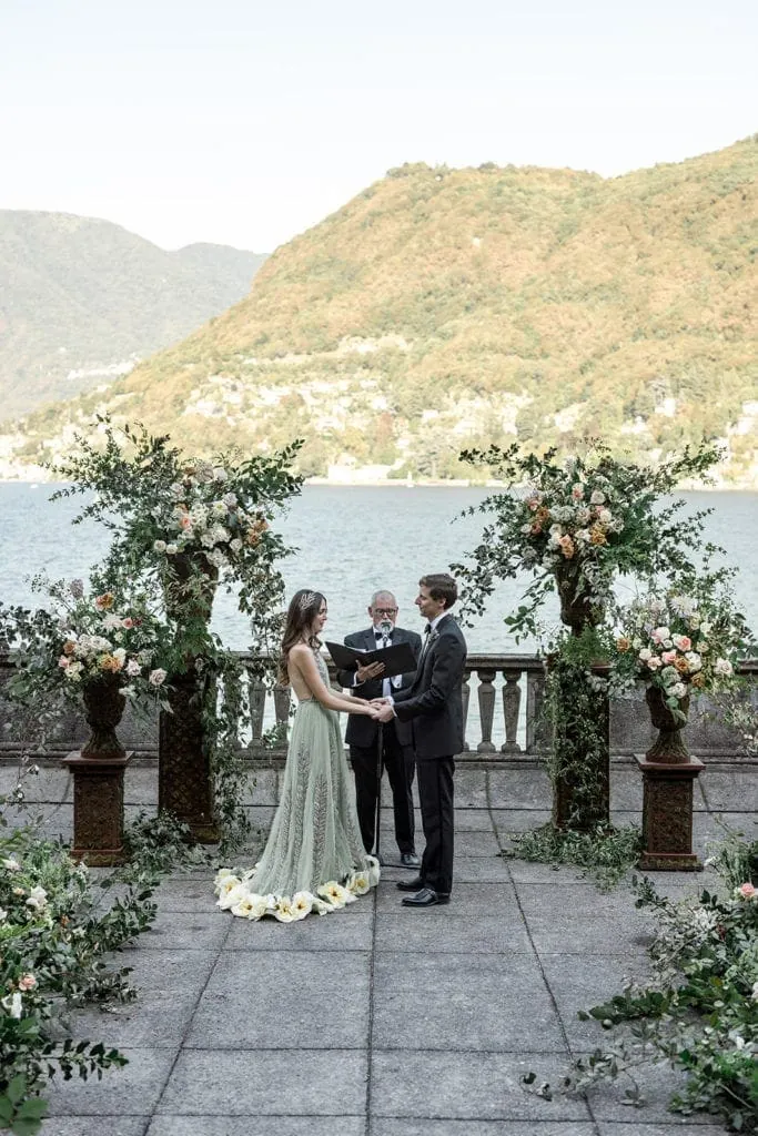 Bride and groom stand for marriage ceremony in Lake Como