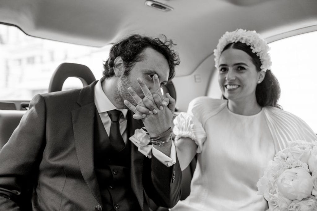 Groom kisses bride's hand in back of car before Chelsea Old Town Hall elopement ceremony