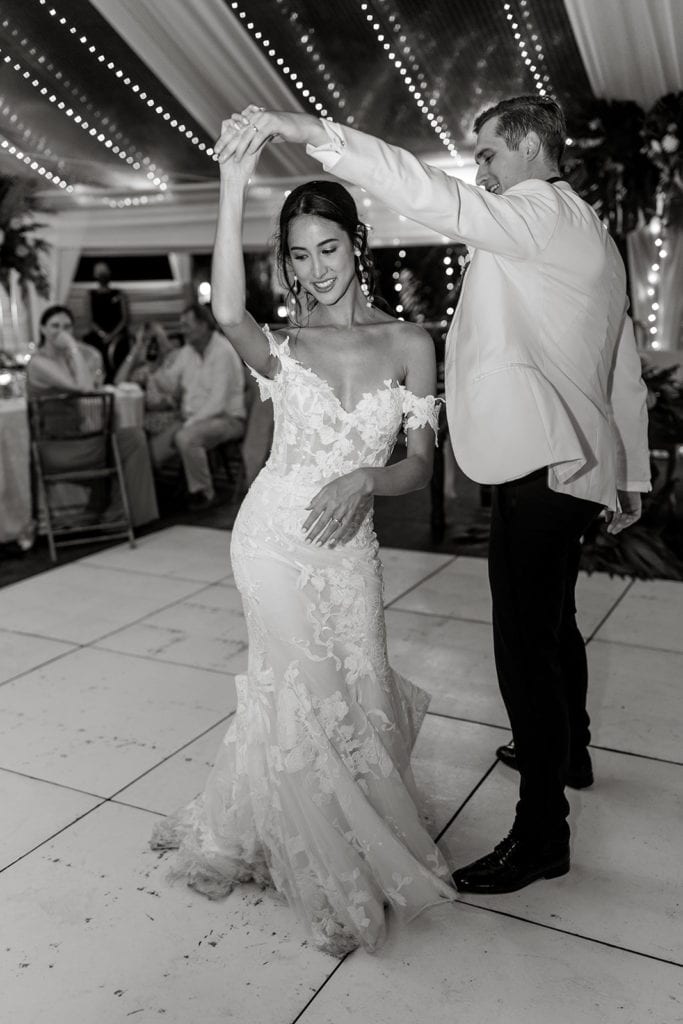 A groom spins his bride while dancing during the wedding reception