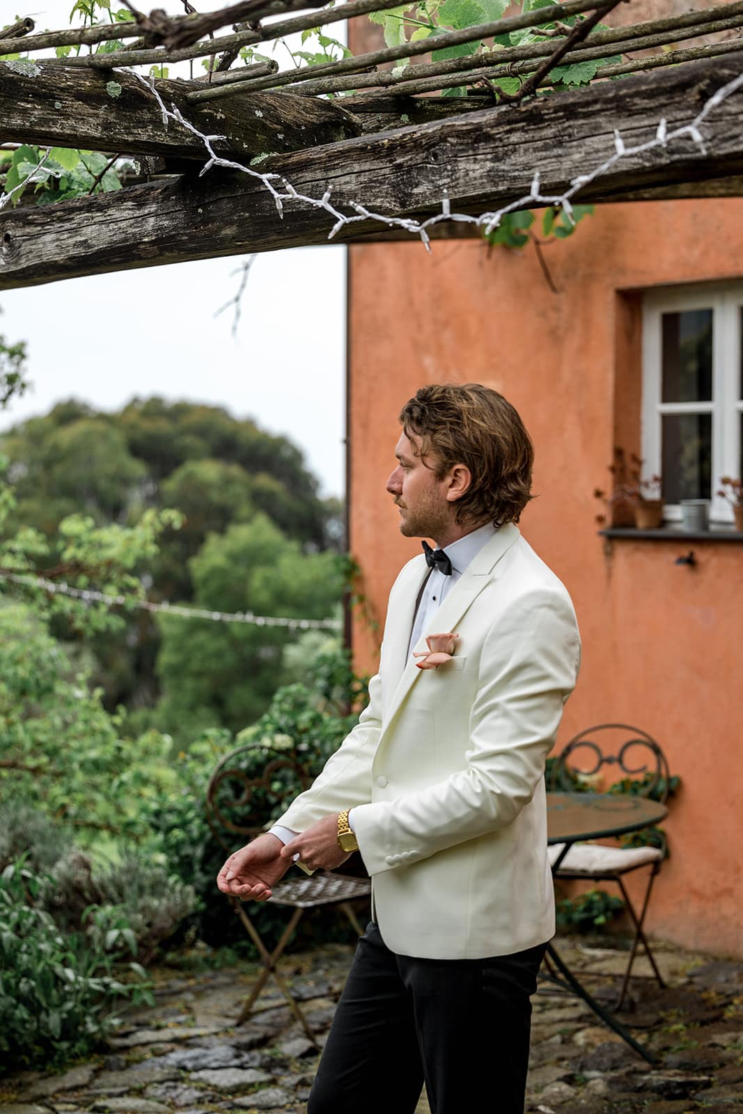 Groom gets ready for wedding in front of an Italian farmhouse