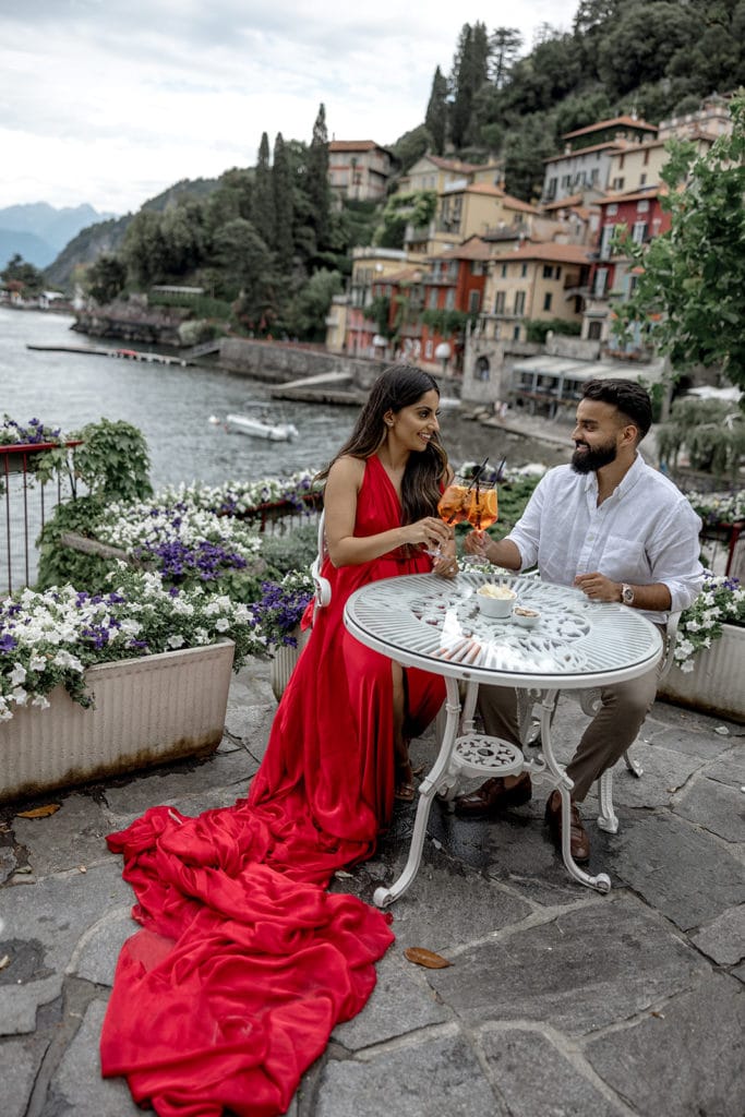 Couple share aperitivo in lake Como during engagement photo session after understanding the purpose of engagement photos