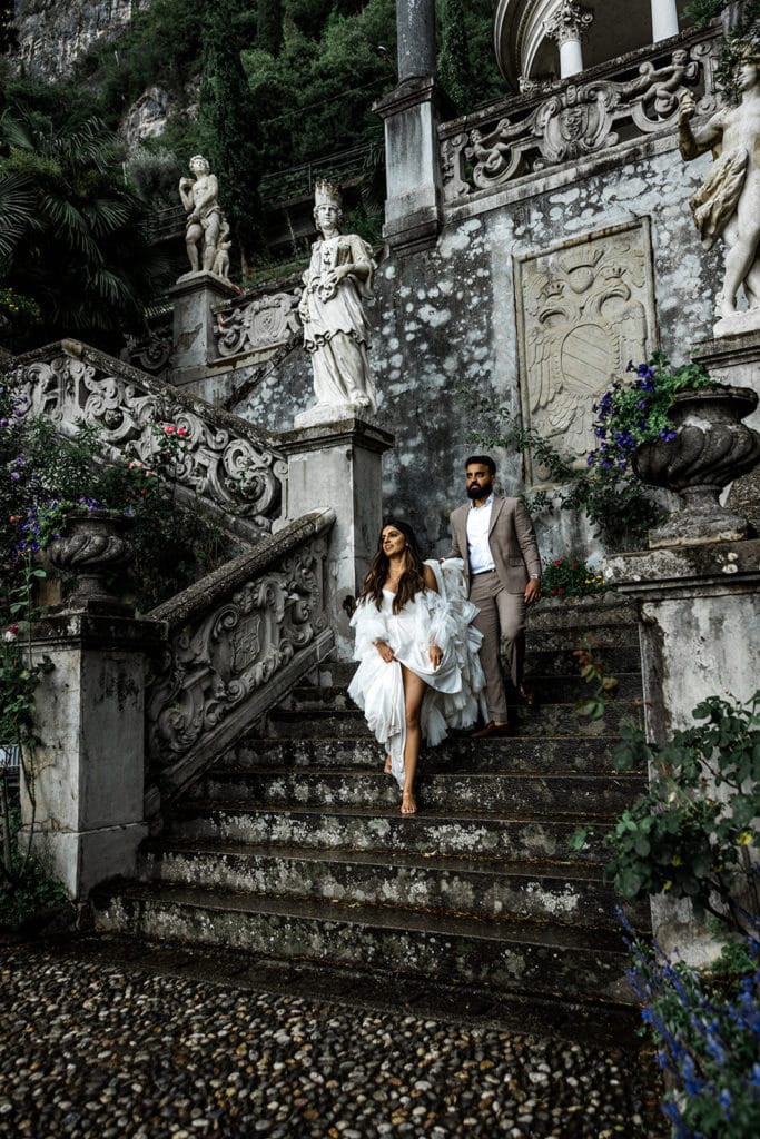 Man and woman walk down grand staircase at Villa Monastero