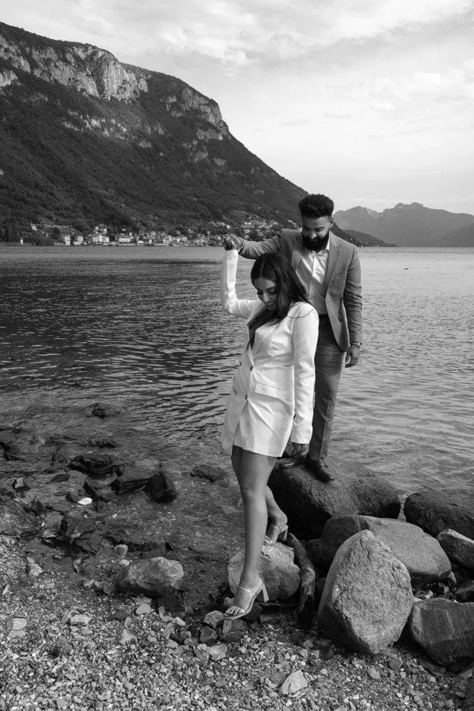 Man and woman walk Lake Como shore for engagement session after learning the purpose of engagement photos