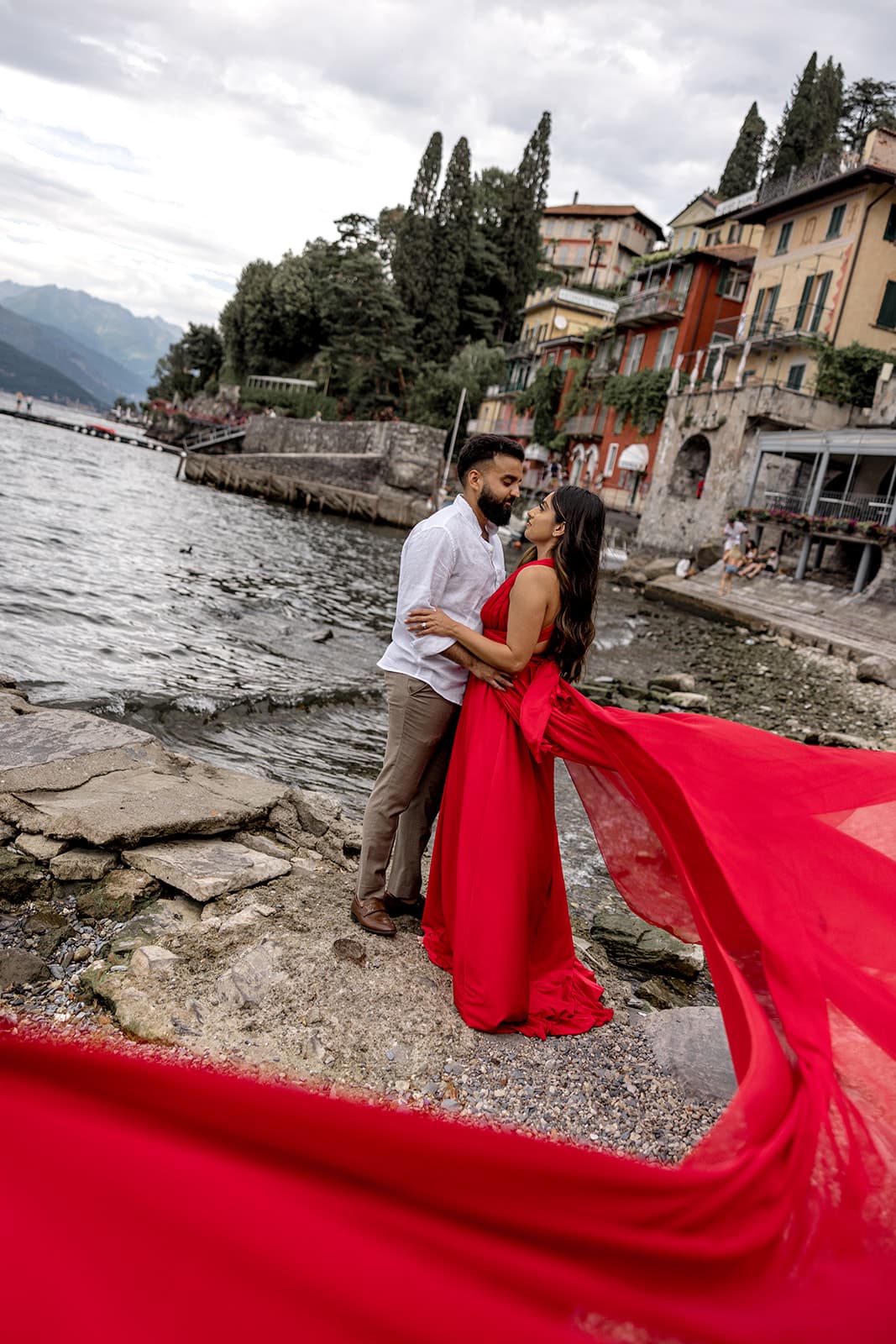 Woman wears red dress during Lake Como engagement photos