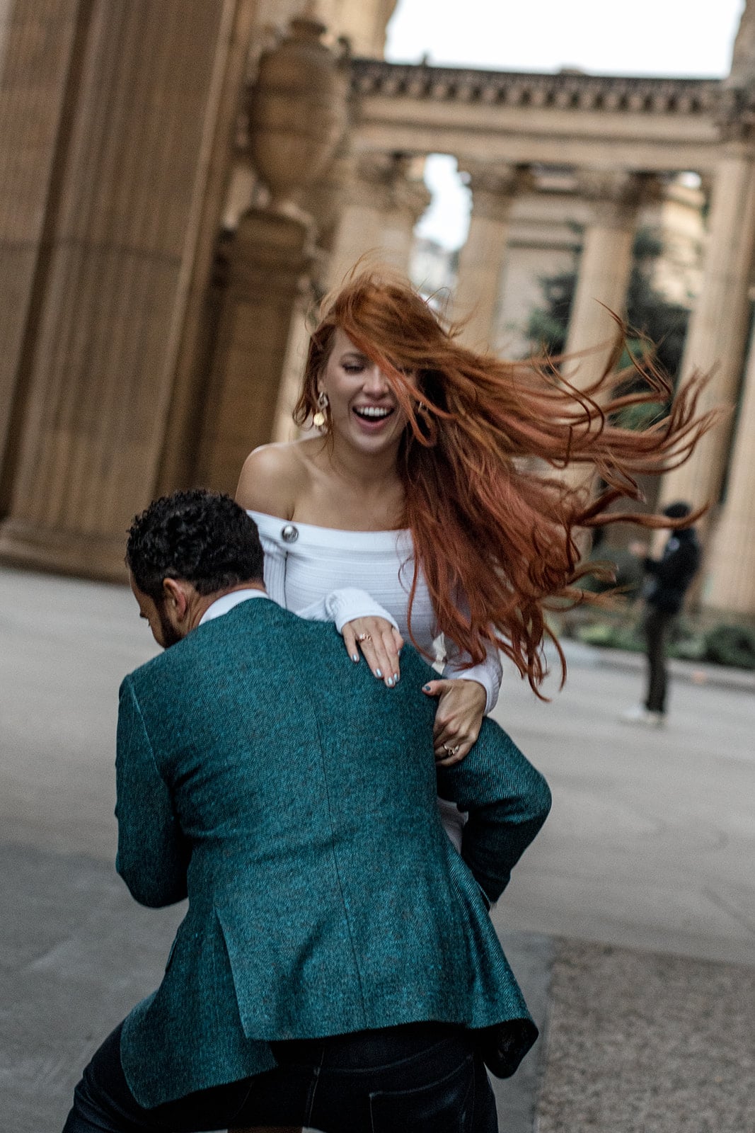 Man carries woman while laughing