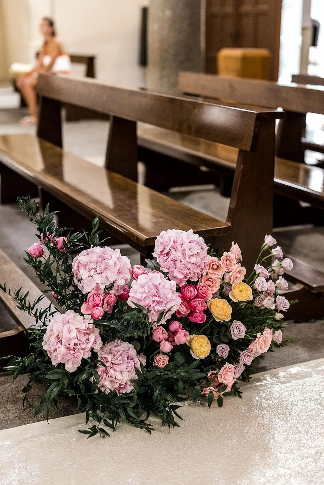 Aisle floral arrangement during church wedding ceremony