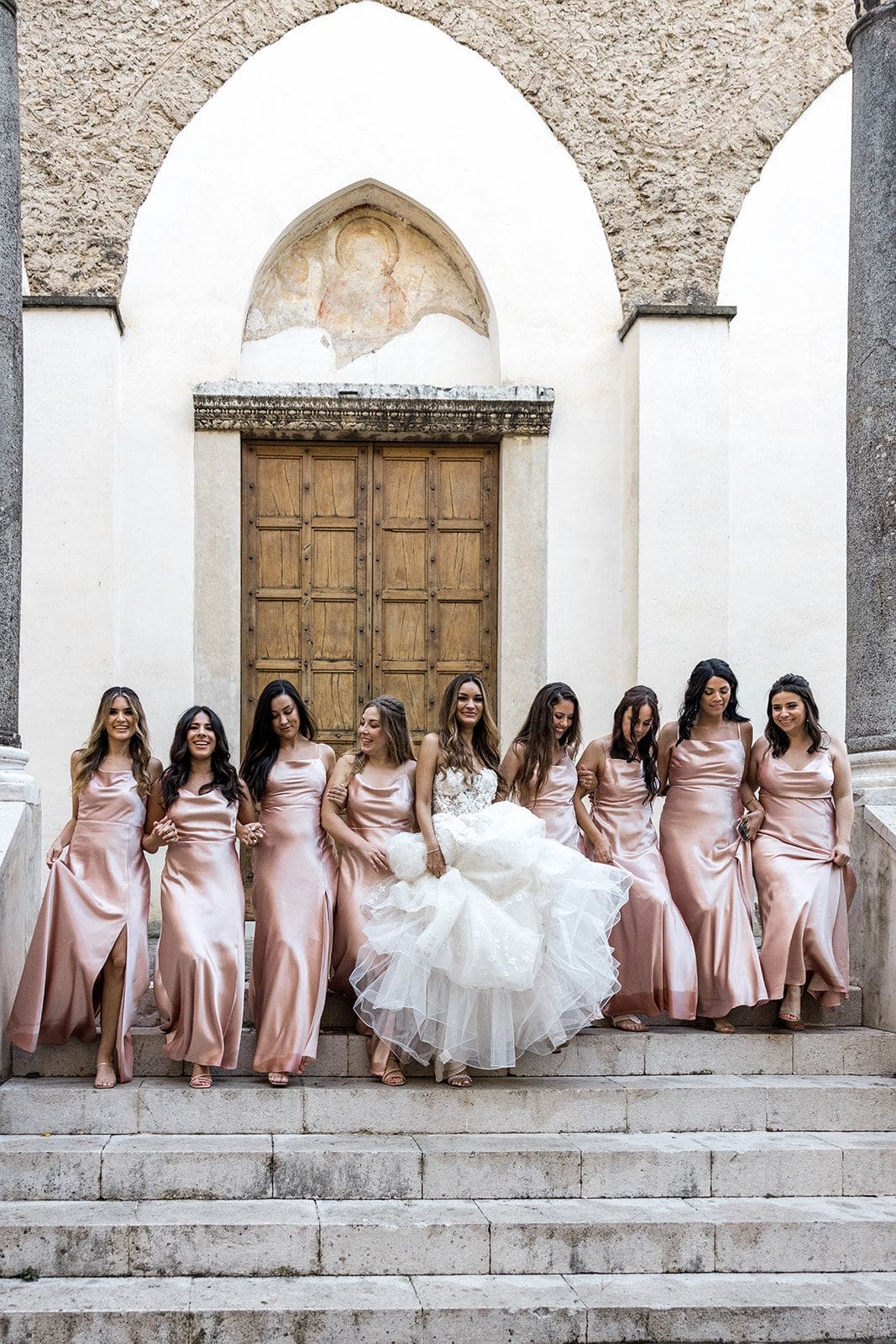 Bride with bridesmaids in pink bridesmaids gowns at church in Ravello Italy