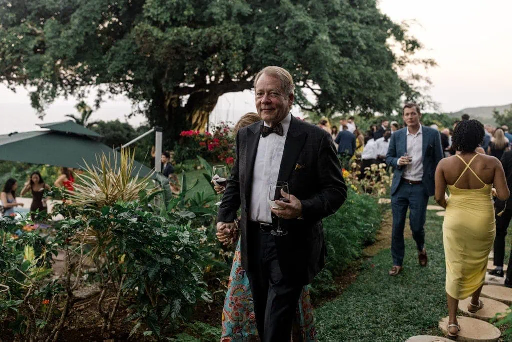 A man holds a wine glass at a wedding venue in Jamaica