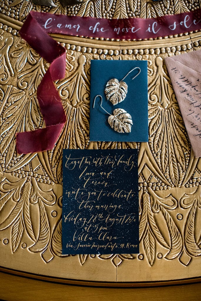 A navy, merlot, and gold color palette for a Rome wedding invitation suite