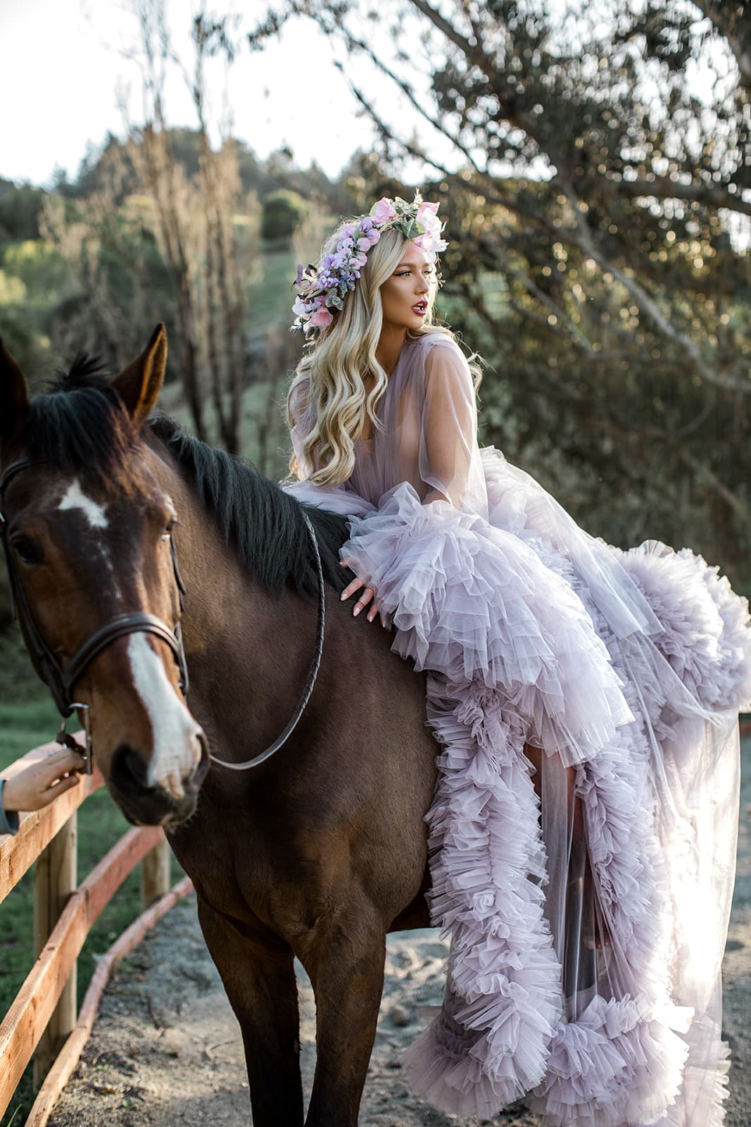 Model atop horse with flower crown and luxury robe