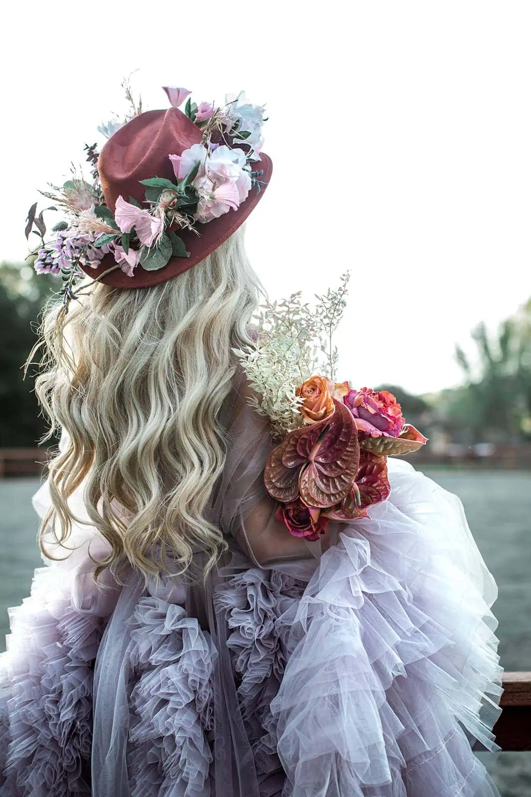 Model wears burgundy hat with flowers
