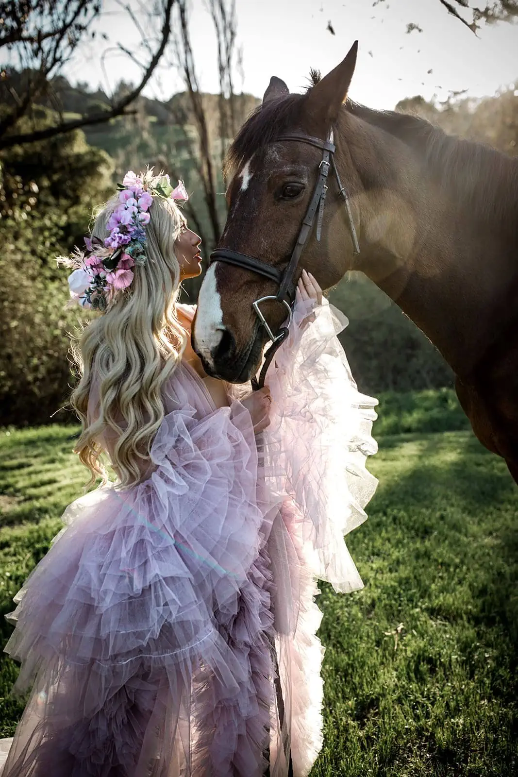 Model kisses horse's muzzle wearing purple bridal robe