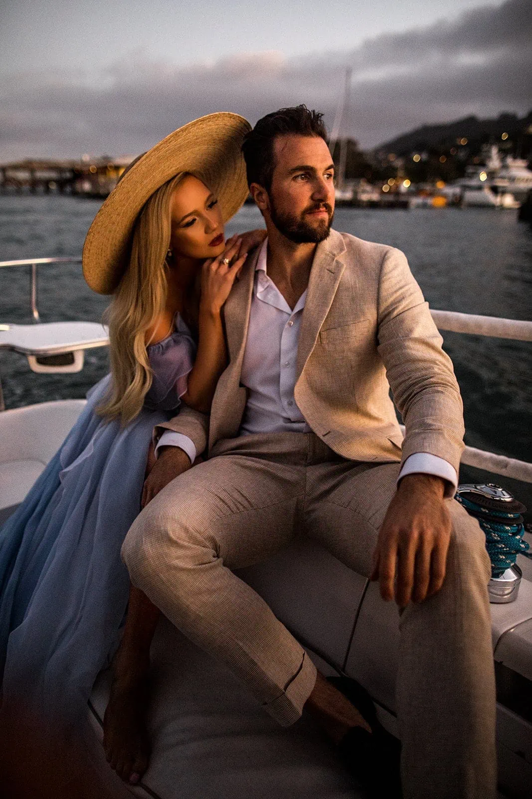 Couple sit on sailboat during engagement photo session