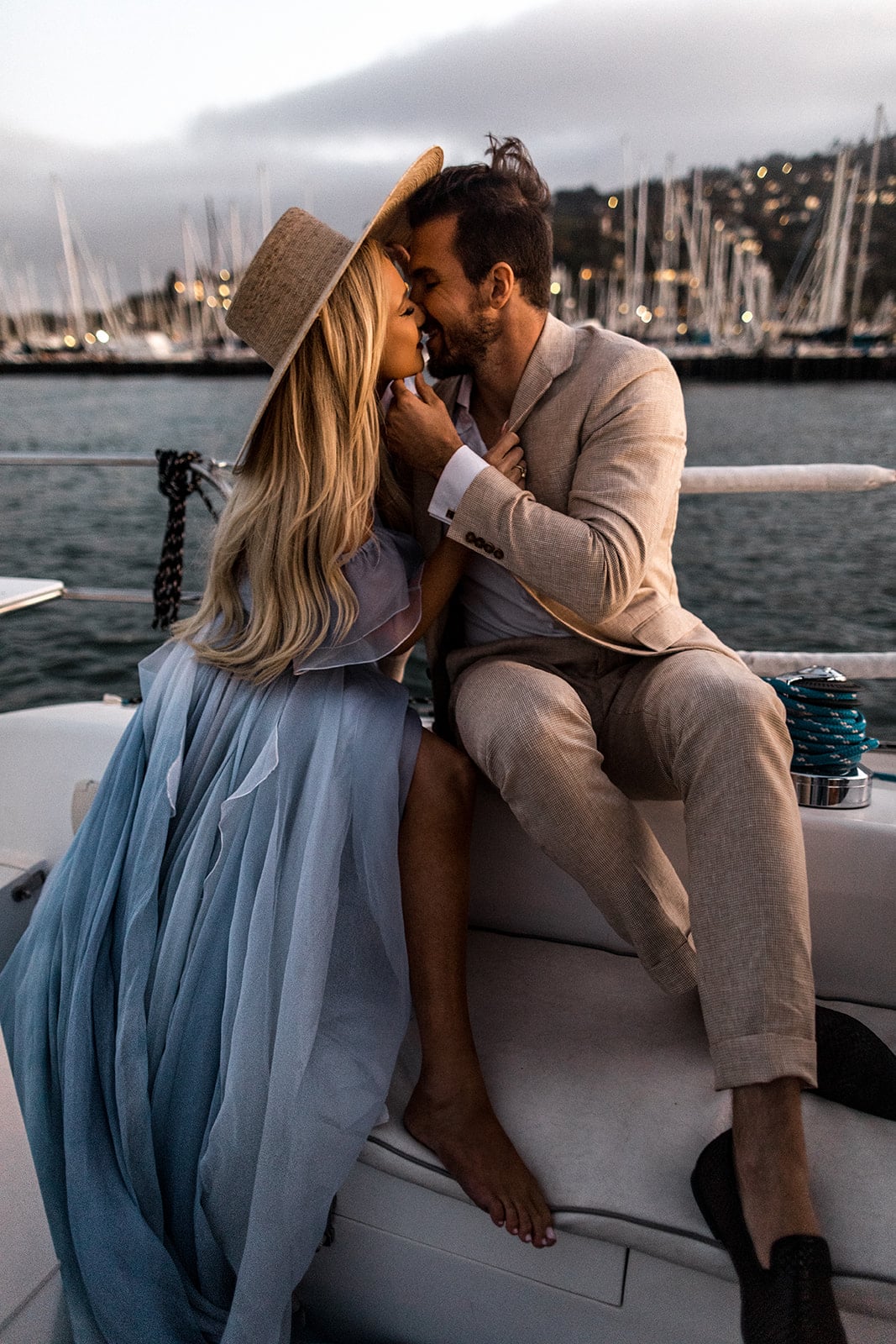 Couple kiss on sailboat during engagement session