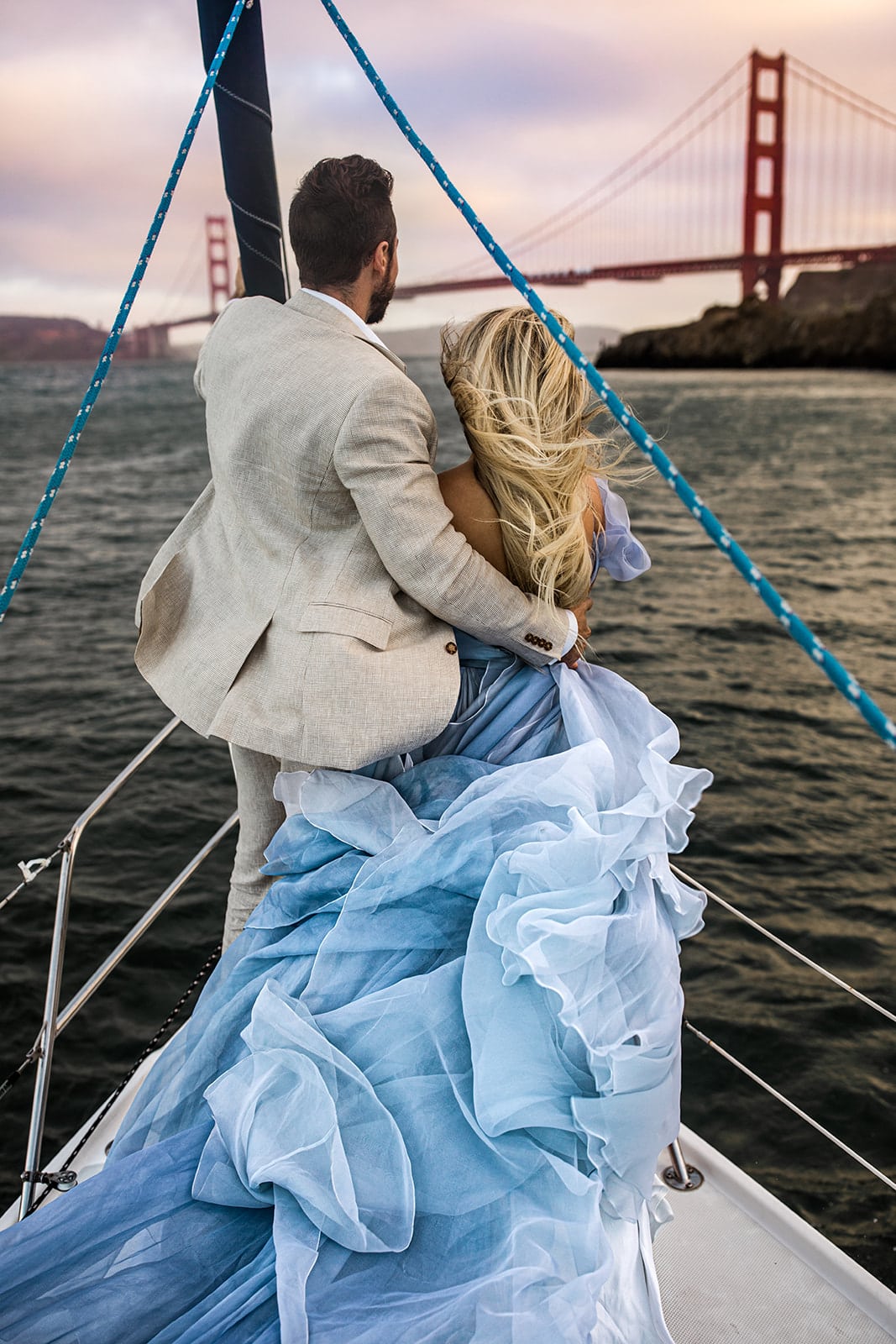 Couple stand on sailboat for San Francisco engagement