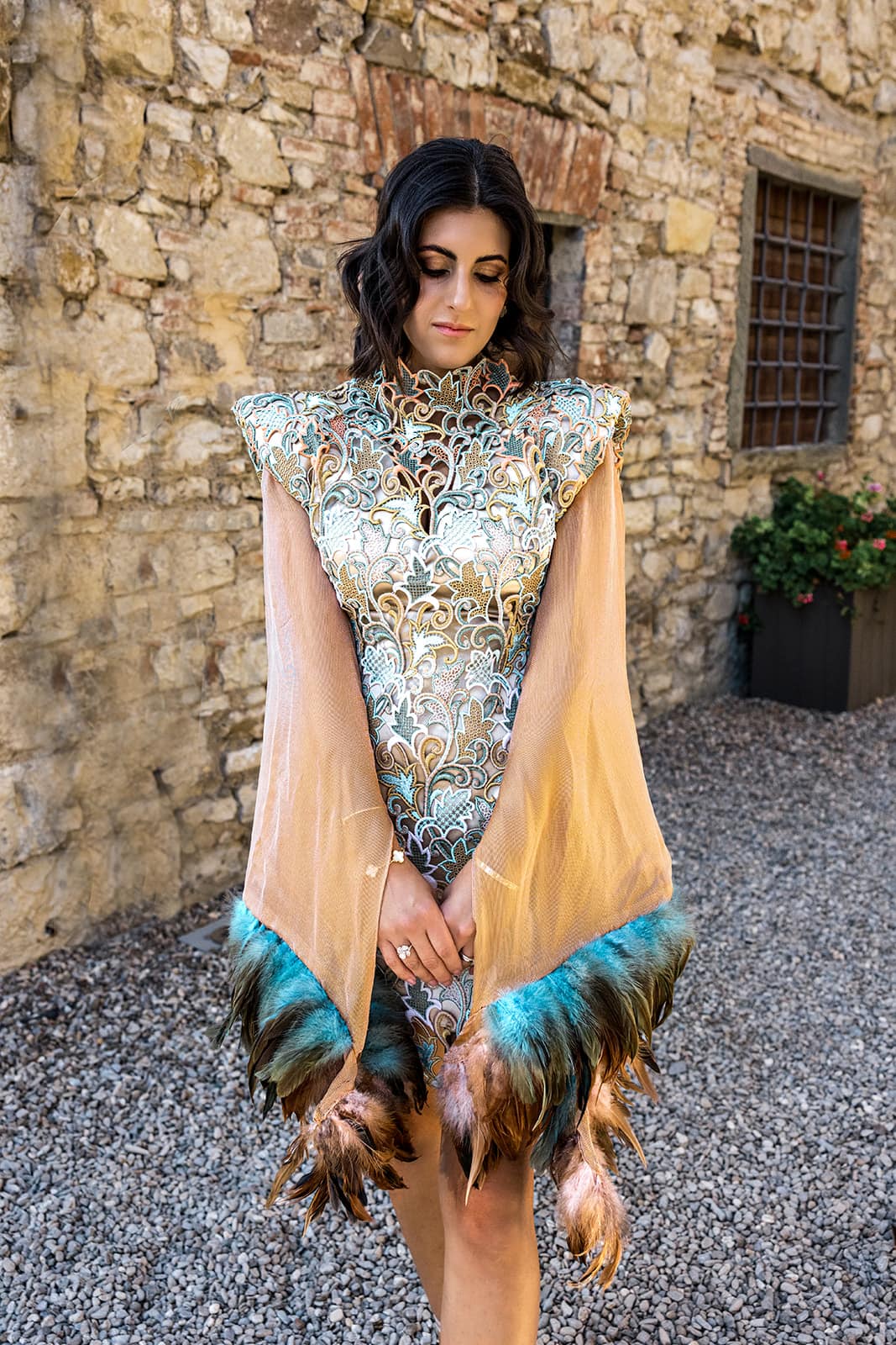 Woman wears custom made couture dress with real feathers