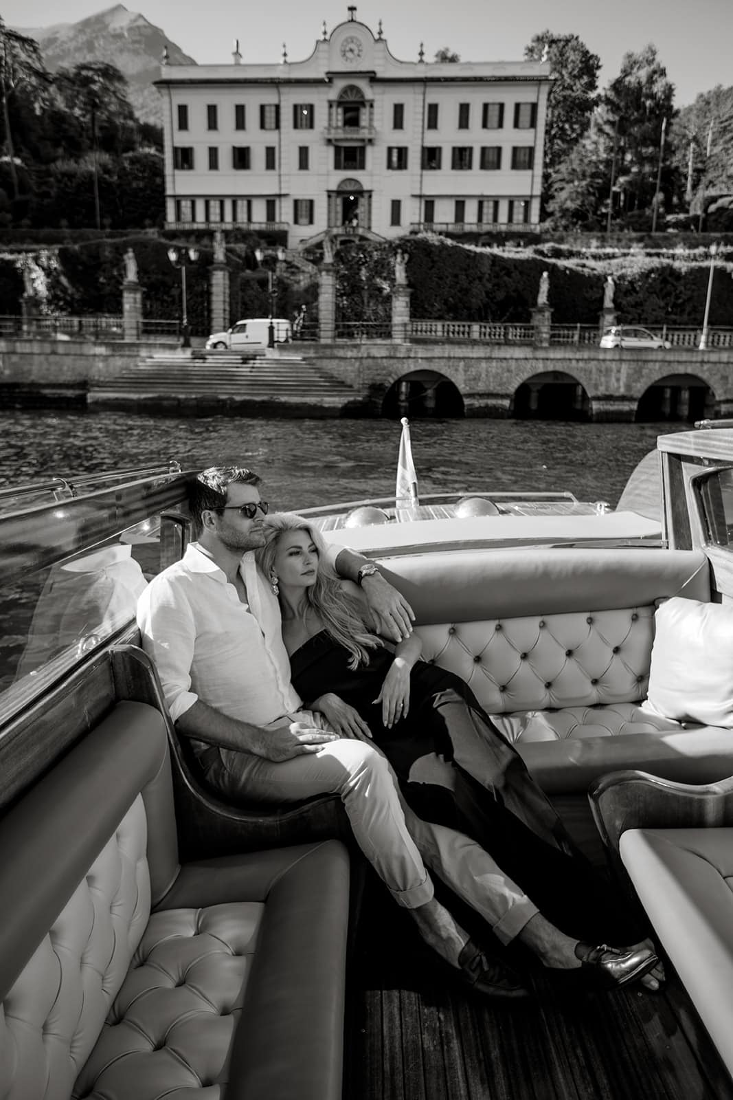 Couple lounge on riva while passing by an Italian villa in Lake Como