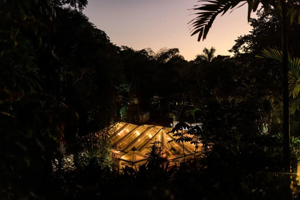 A large tent is lit up in the heart of the Jamaican rainforest for an estate wedding reception