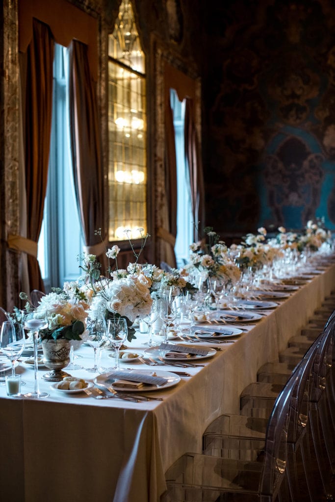 Banquet-style tables at Villa Erba with many cream-colored rose centerpieces