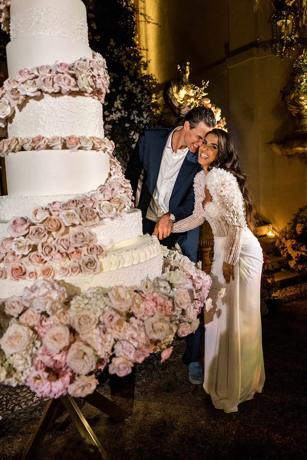 Bride and groom cut massive wedding cake together