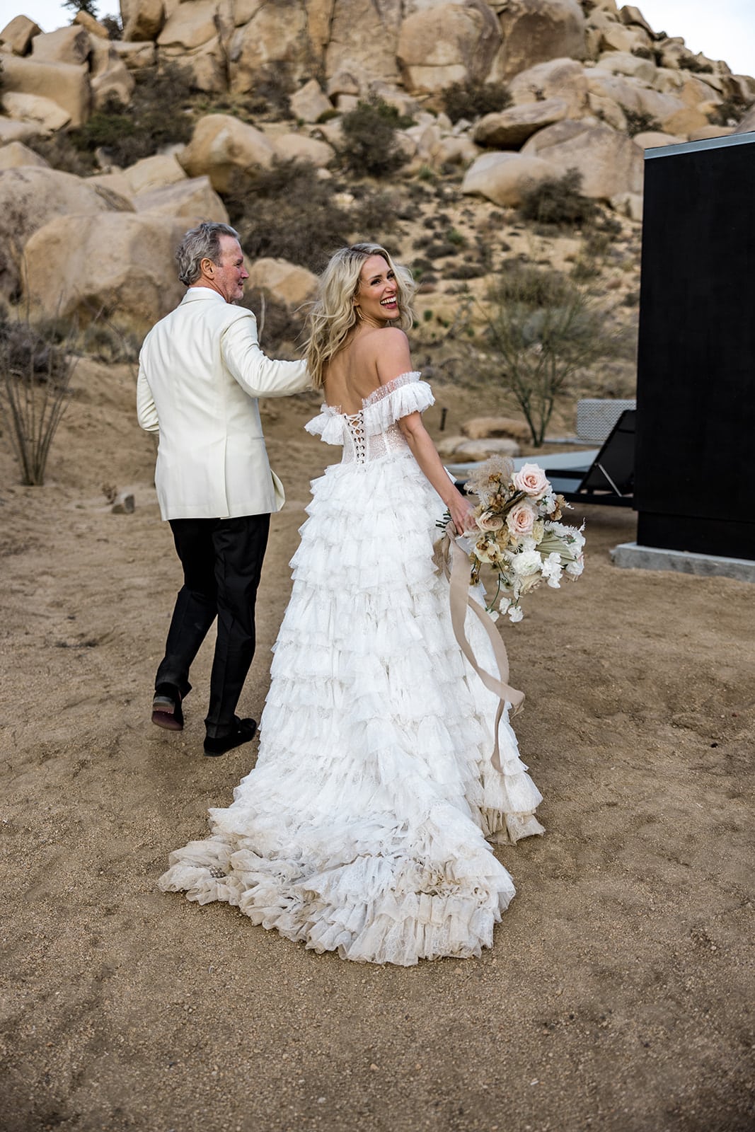 Bride and groom walk in the desert to their AirBnB