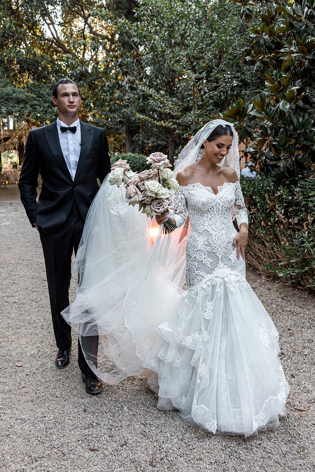 Bride and groom walk on garden path at Villa D'Orri