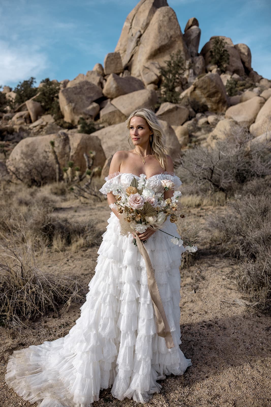 Bride holds bouquet in Joshua Tree desert