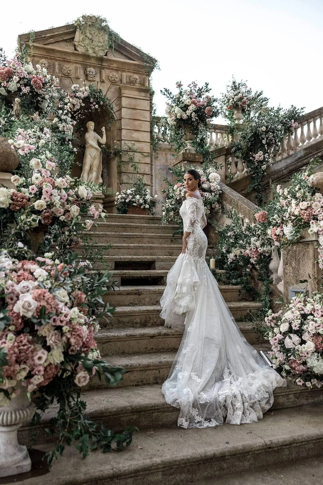 Bride stands on grand staircase at Villa D'Orri