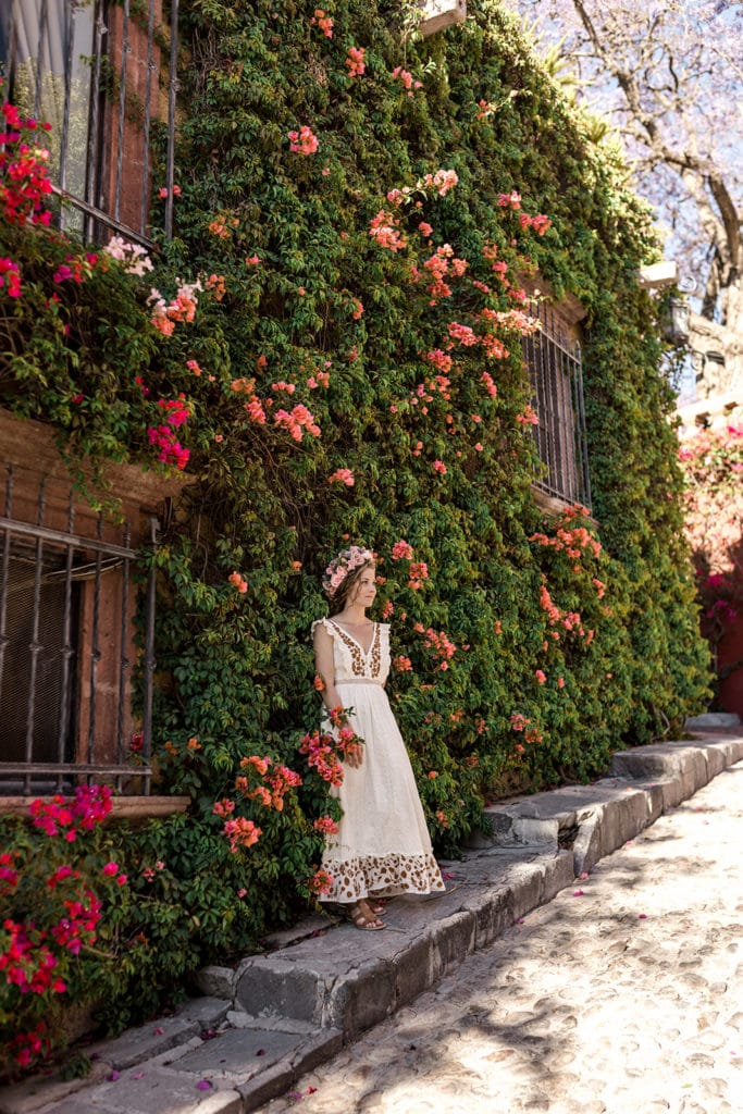 Bride stands against wall of flowers in San Miguel de Allende