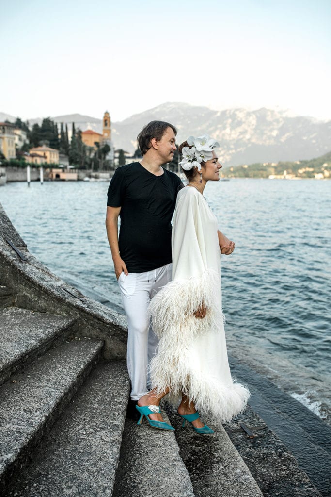 Couple stand together overlooking Lake Como for their engagement photos after learning the purpose of engagement photos