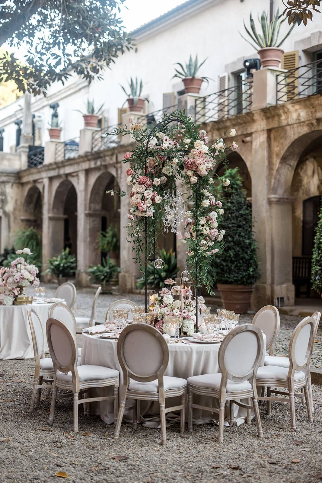 Floral arch stands on reception tables in Sardinia wedding reception