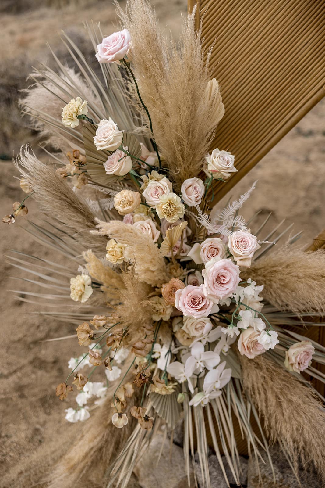 Pampas grass and pink and white roses serve as floral arrangement for wedding ceremony decor