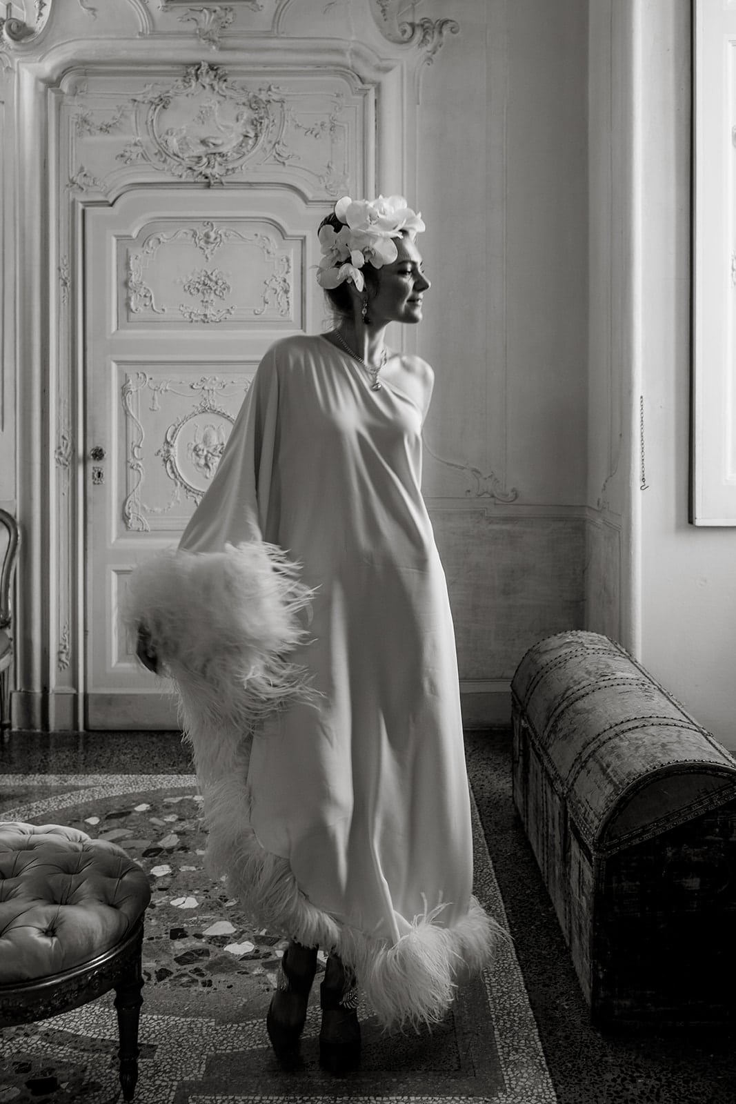 Woman wears feather-trimmed dress inside Villa Sola Cabiati