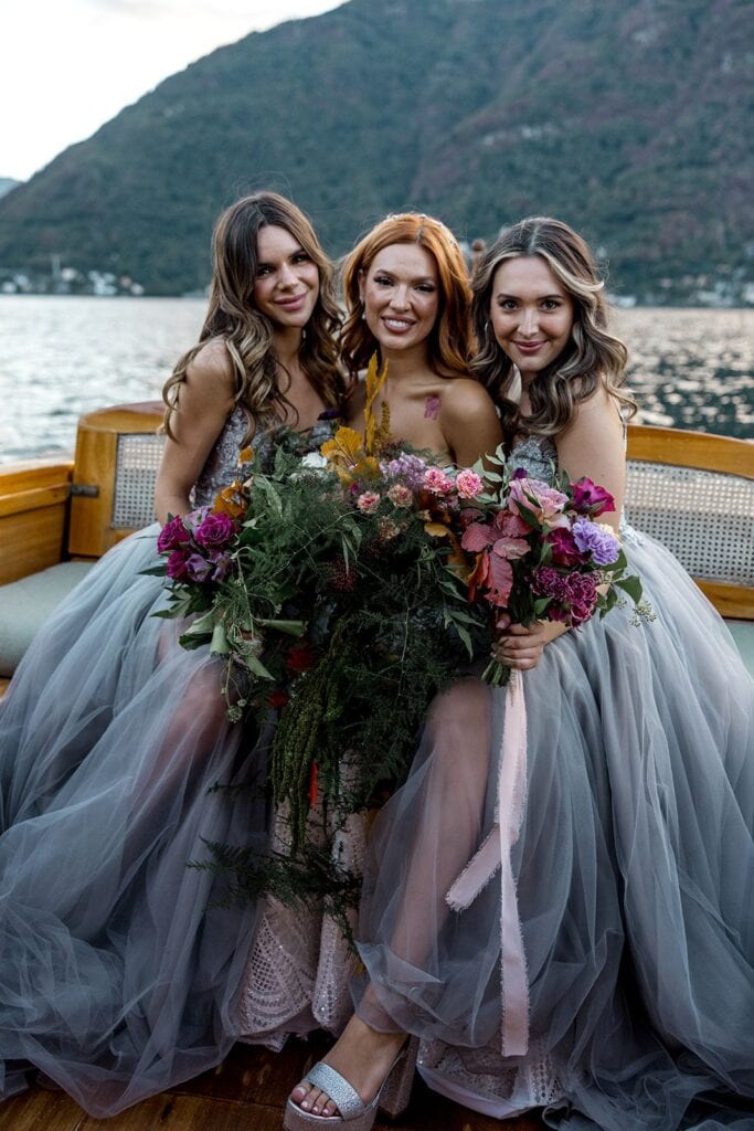 Bride hugs bridesmaids on a boat on Lake Como