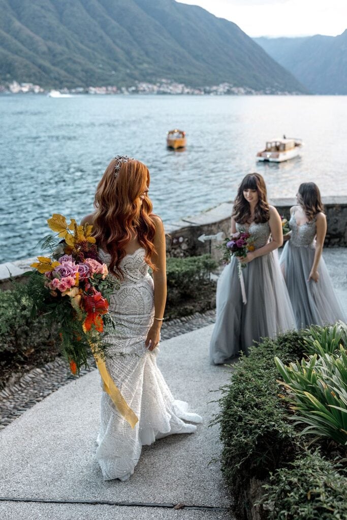 Bride walks up to ceremony site at Villa del Balbianello with bridesmaids