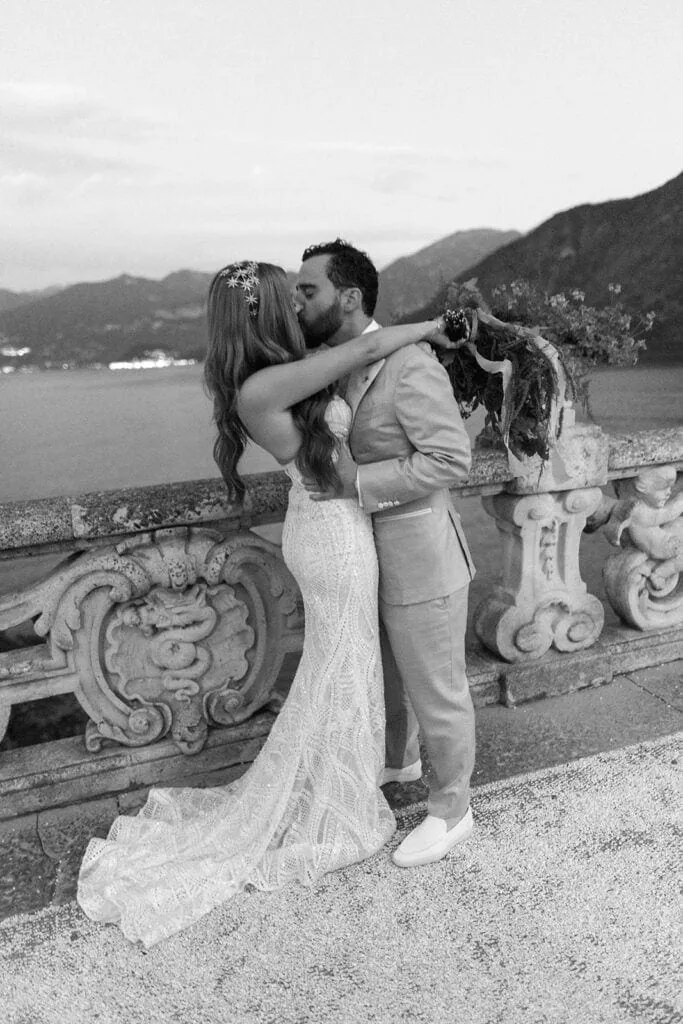 Bride and groom kiss on terrace at Villa del Balbianello