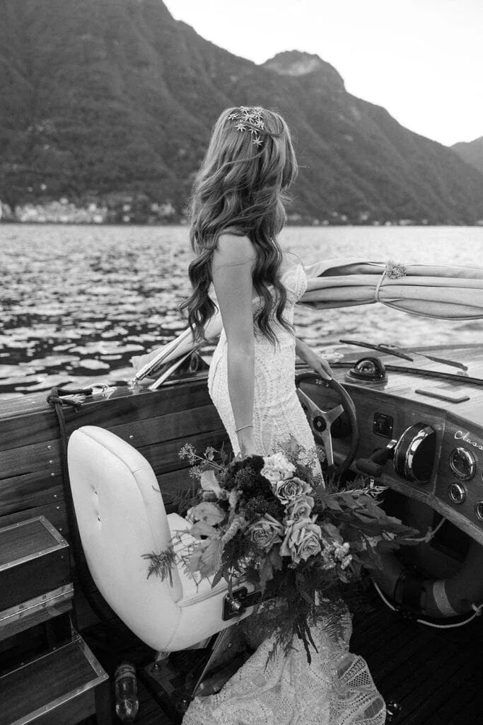 Bride stands on a boat on Lake Como