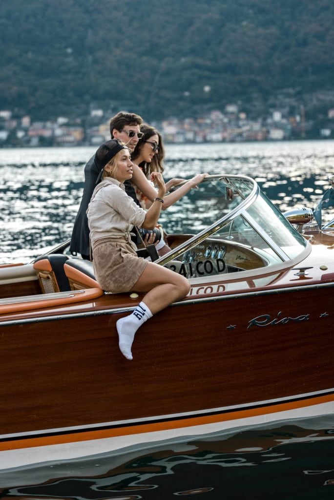 Photographer sits on a boat in Lake Como with a couple as they plan their next photos