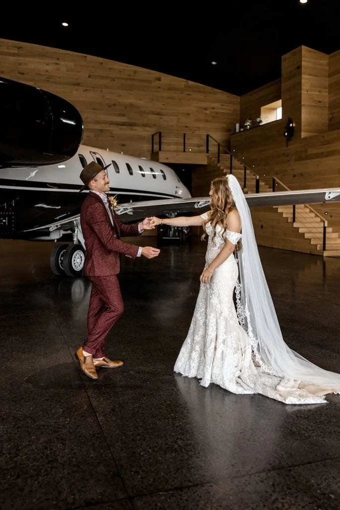 Bride and groom share first look during aviation themed wedding