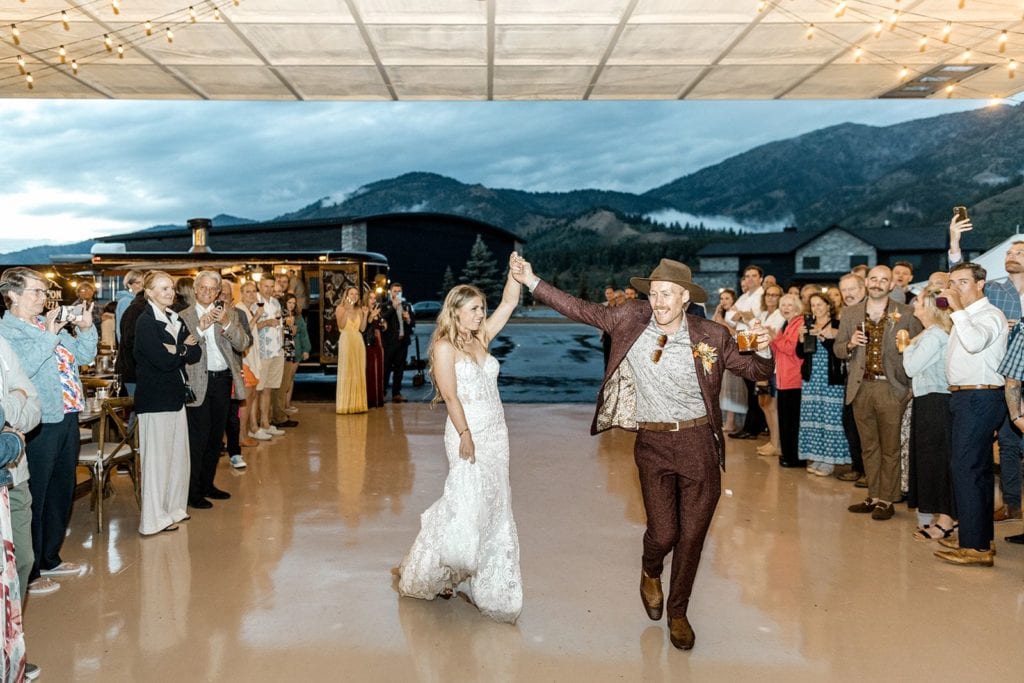 Bride and groom enter reception in an airline hangar in Wyoming wedding
