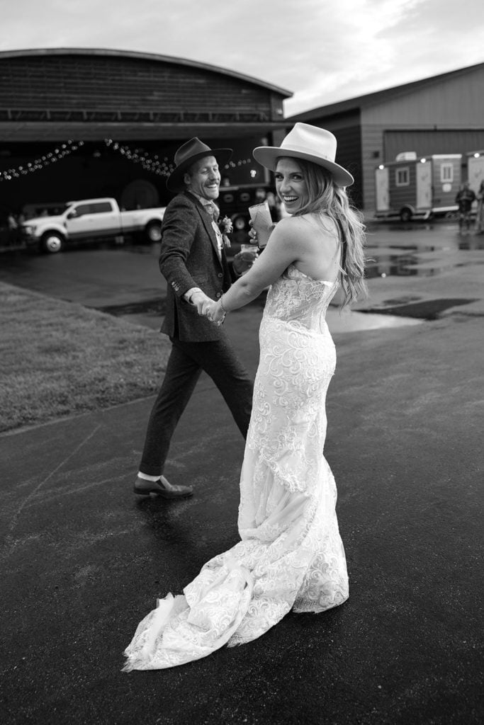Bride and groom walk on a plane runway during their Wyoming wedding at a private airport
