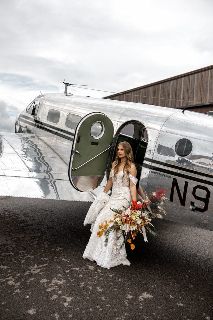 Bride sits on vintage airplane