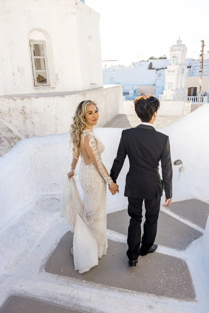Bride and groom walking down stairs in Santorini Greece